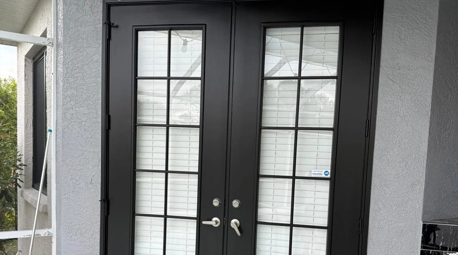 Black French doors and freshly painted trim on a Florida lanai