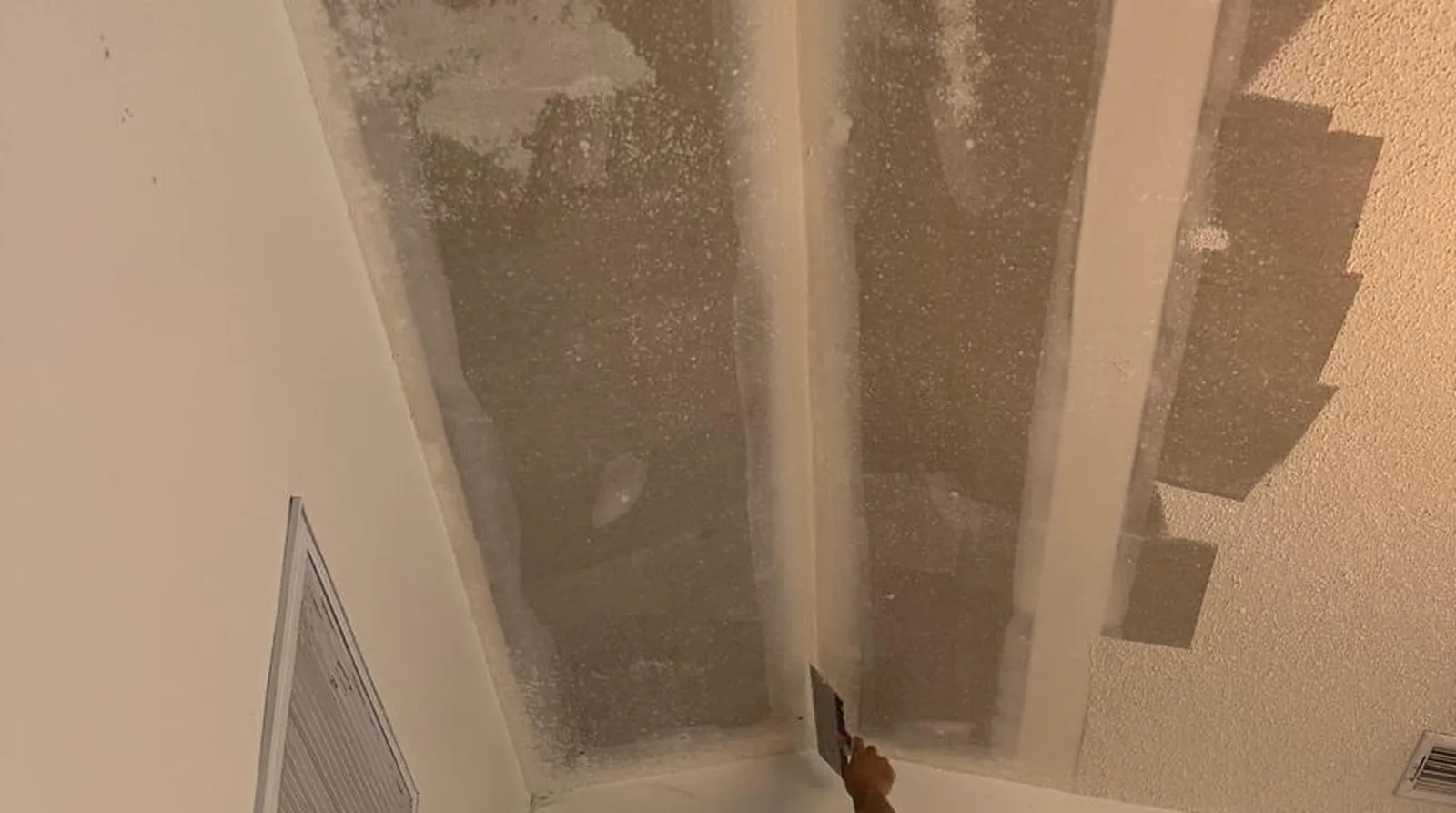 Popcorn texture being scraped off a ceiling and skim-coated smooth by WCS Prime Services in Sarasota, FL