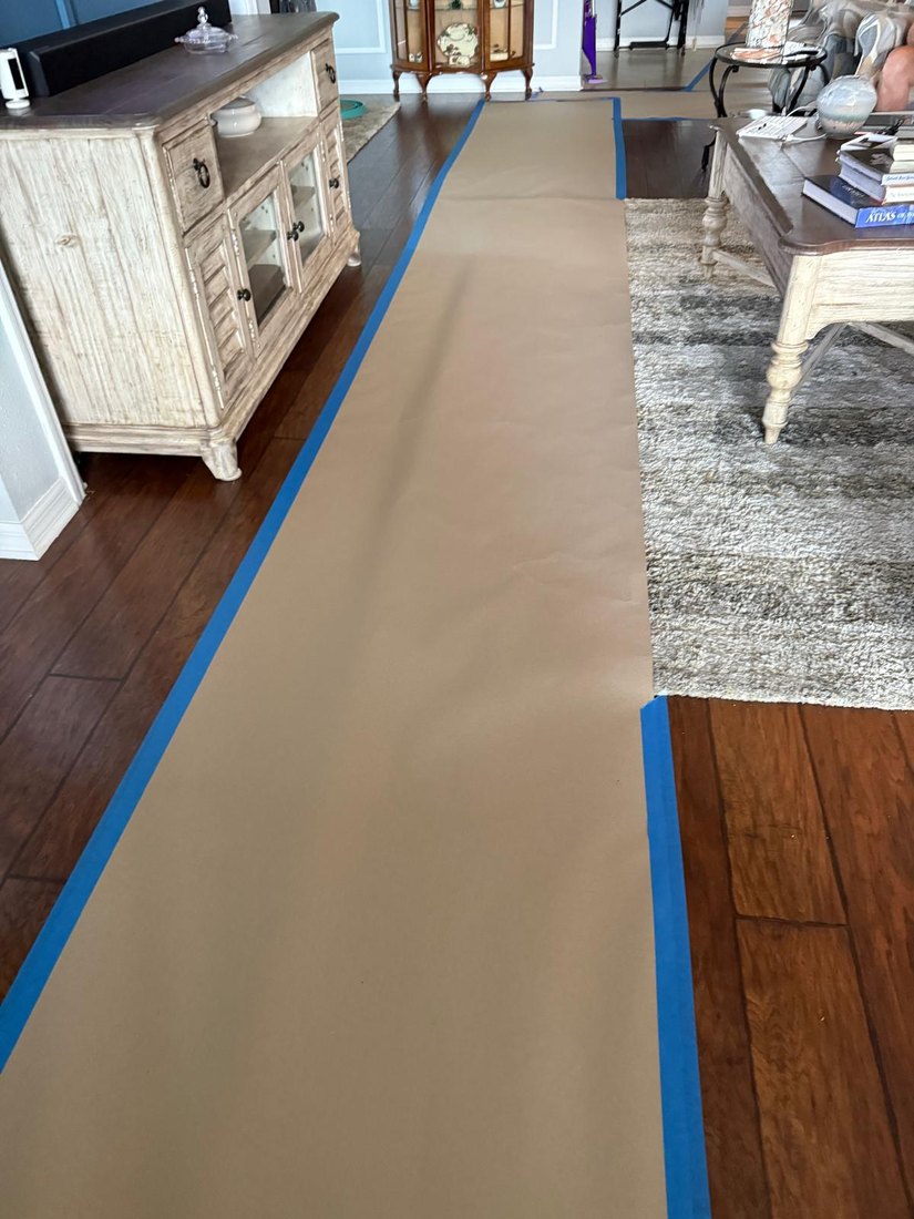Floors papered and taped wall to wall through a furnished home before interior painting